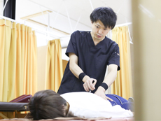 患者が仰向けの状態で腰部を施術するようす